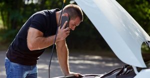 Man on the phone inspecting a car