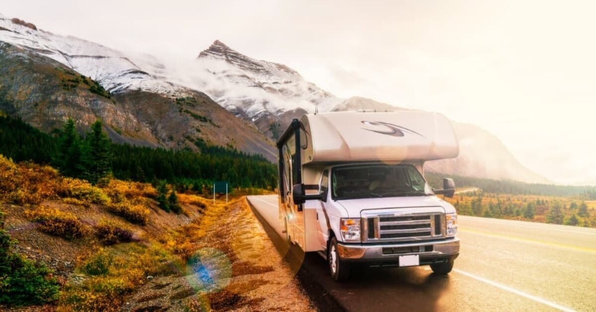 An RV traveling along mountain roads after finding the best in RV roadside assistance plans.