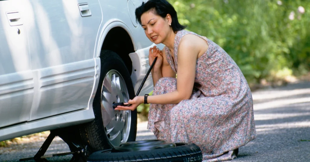 women changing a flat tire on the highway