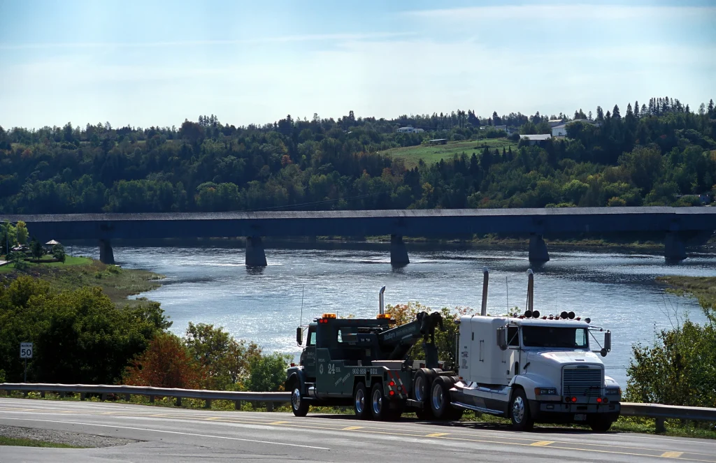 Medium Duty Tow Truck on a Roadside Besides a Lake